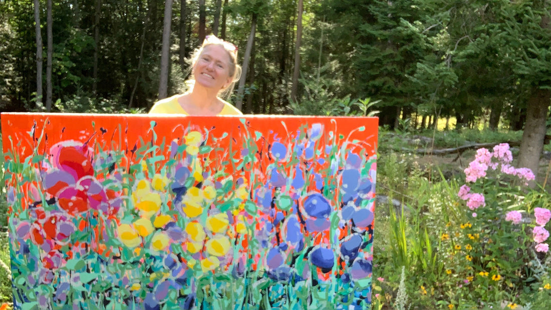 Abstract artist Claire Desjardins, stands outside with her summer-inspired painting.