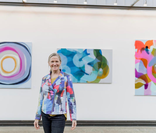 Abstract artist, Claire Desjardins, in front of her abstract paintings.