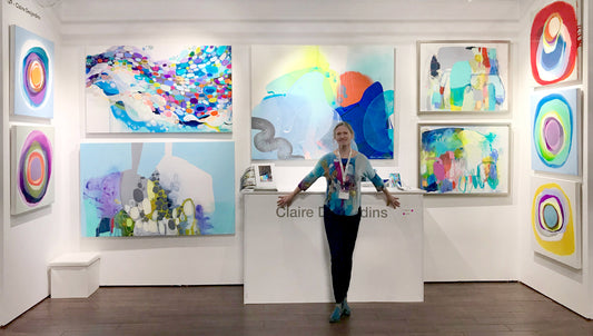 Abstract artist Claire Desjardins with her abstract paintings at art fair.