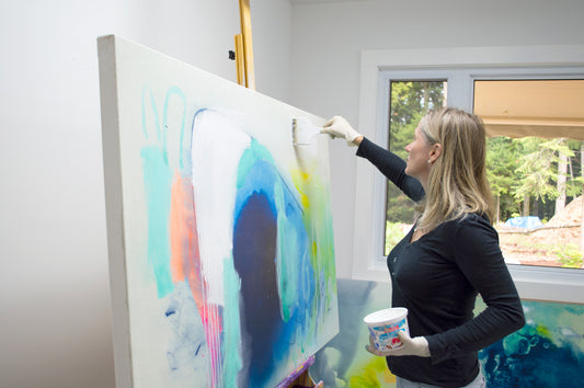 Abstract artist, Claire Desjardins, paints negative space on her painting.