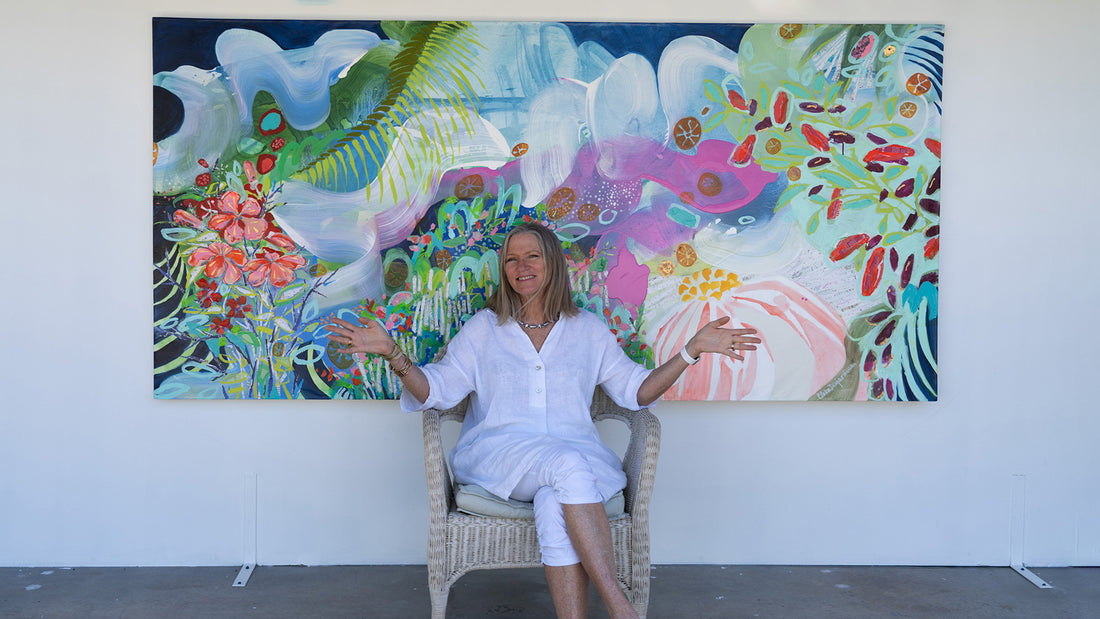 Claire Desjardins sitting in front of her abstract painting, My Tropical Paradise