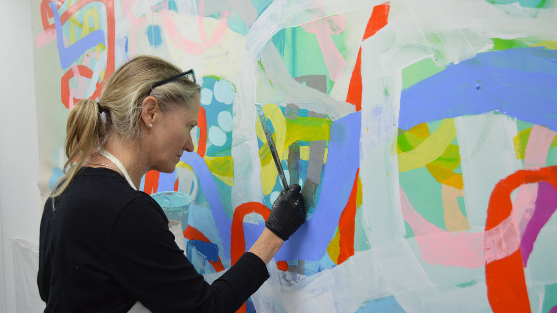 Artist Claire Desjardins, painting a large mural.