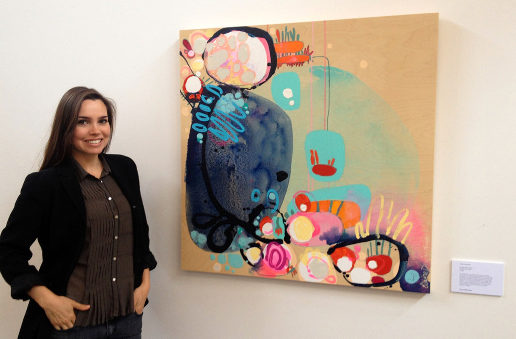 Nicole Garton stands beside abstract painting by artist painter Claire Desjardins at Saatchi Art office.